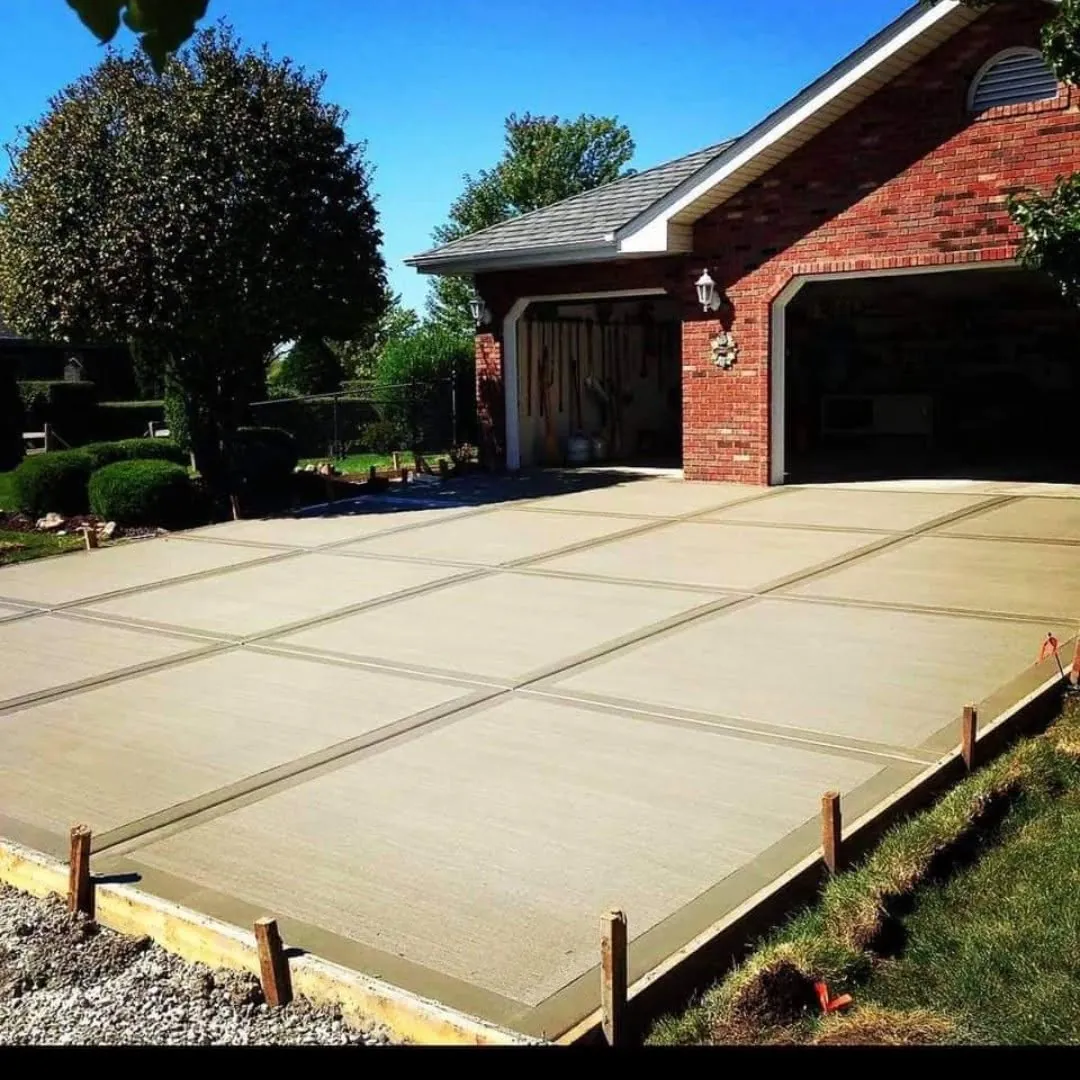 New broom-finish concrete driveway by a brick garage — Sammson Concrete, Calumet City IL