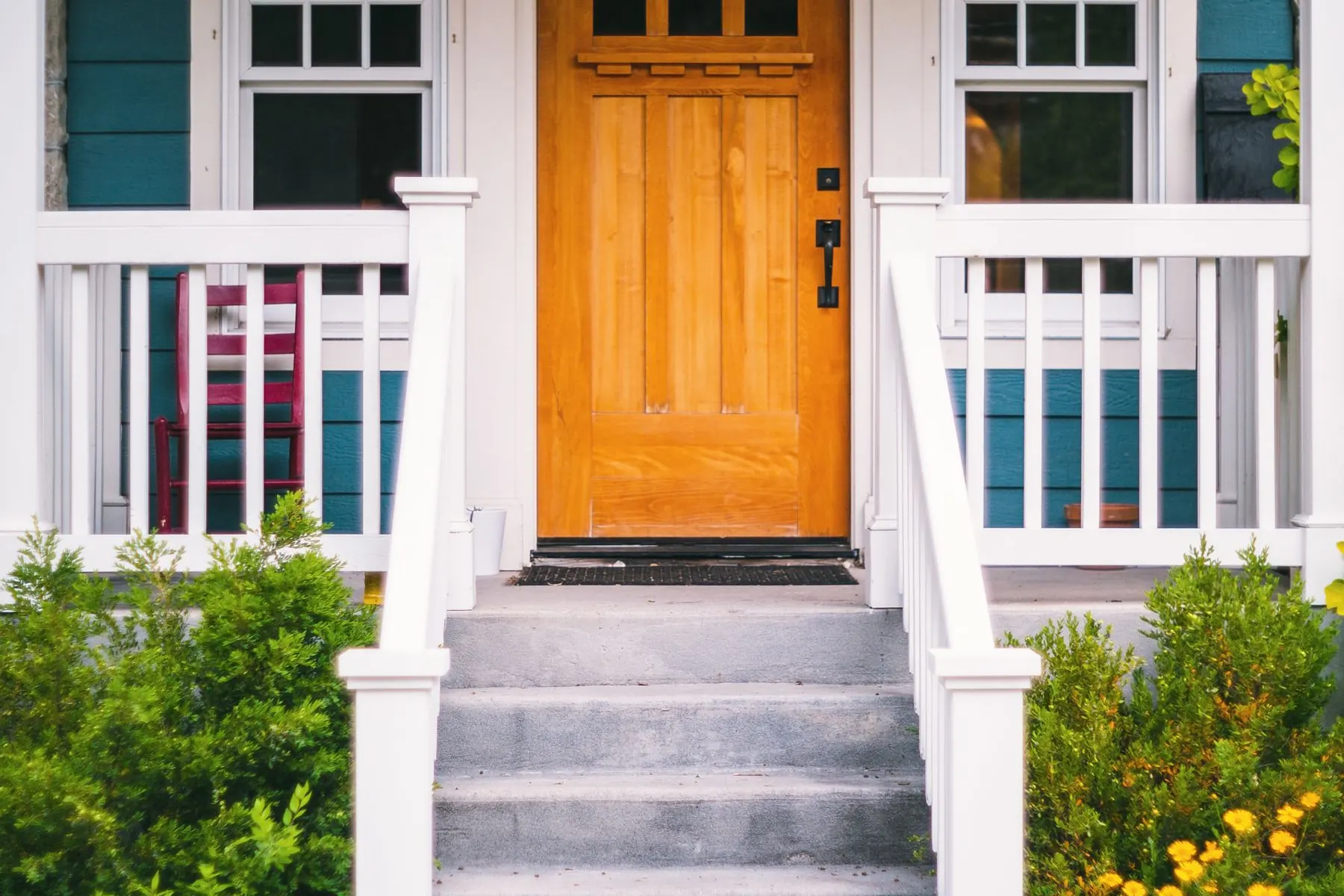Concrete front entrance steps with even risers leading up to the door of a house