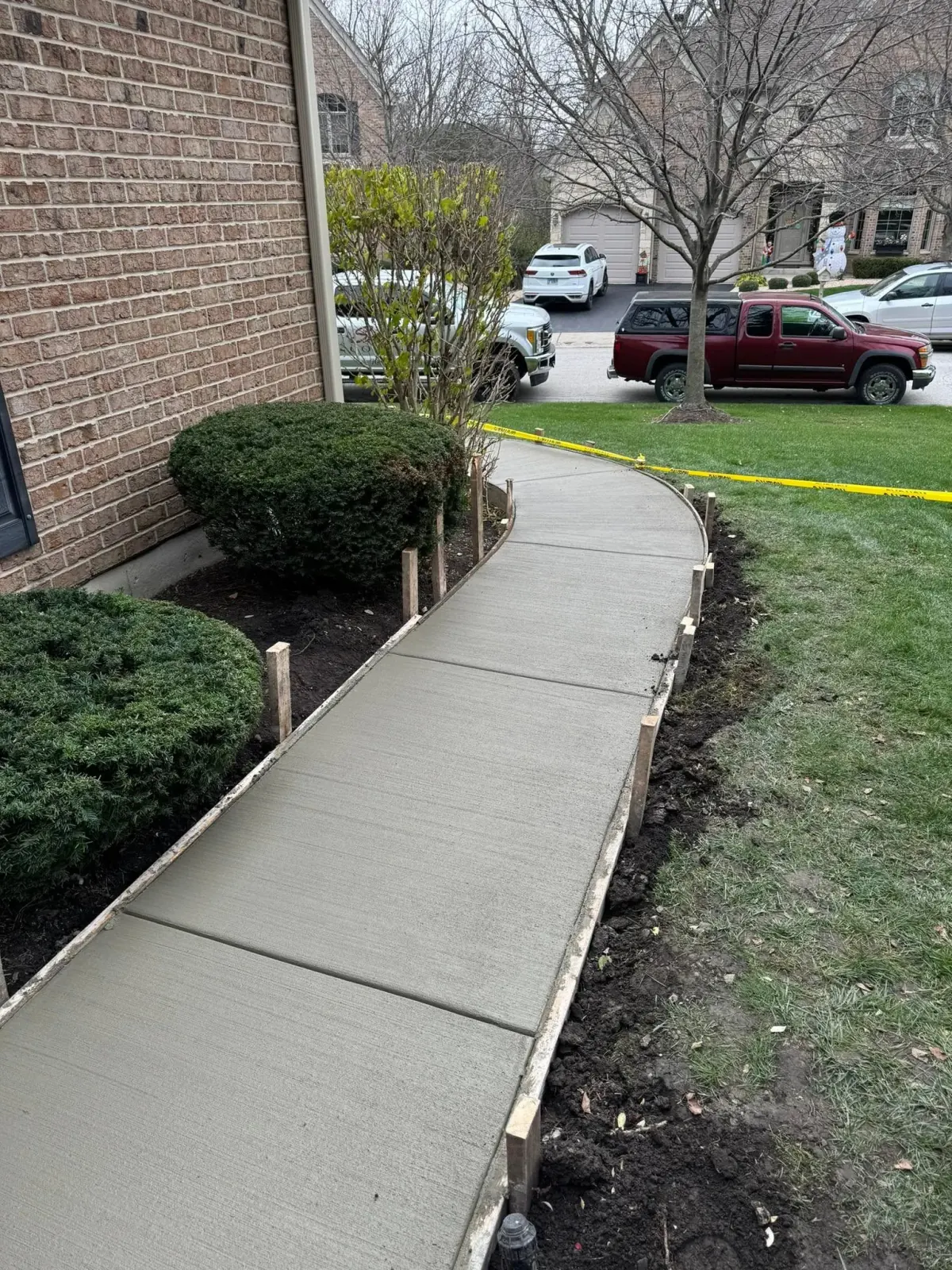Curved concrete sidewalk installation still in its forms — Sammson Concrete, Chicagoland