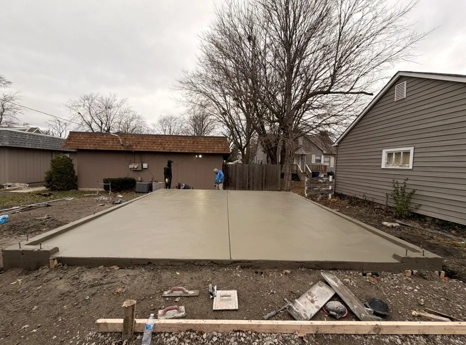 Freshly finished concrete garage slab foundation in a residential backyard